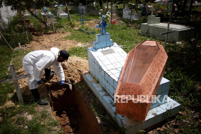Seorang petugas menyiapkan pemakaman warga yang diduga meninggal akibat Covid-19 di wilayah Portel, Pulau Marajo, Brasil, Rabu (10/6). 