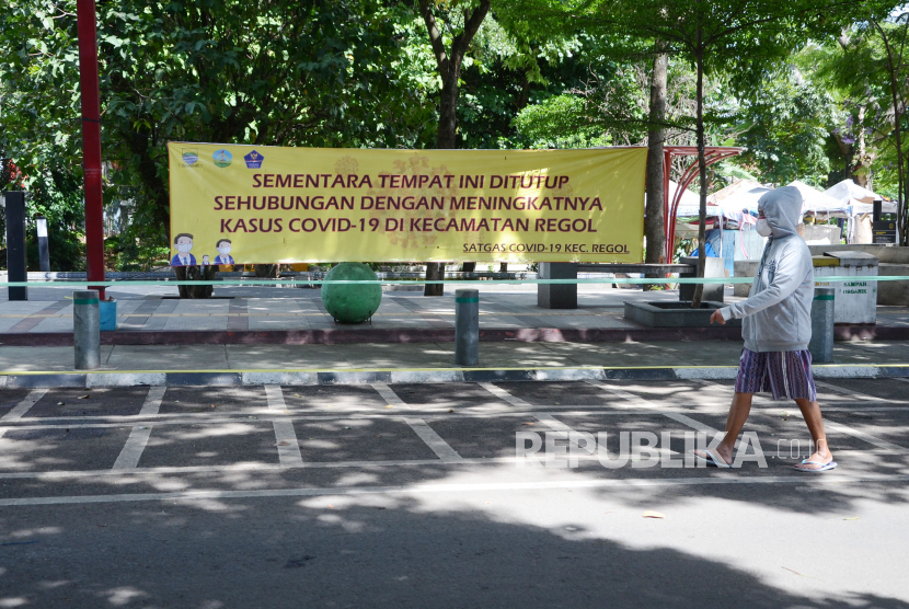Warga berjalan di depan Taman Regol, Kota Bandung, yang ditutup, Kamis (3/12). Penutupan taman dilakukan untuk mencegah penyebaran Covid-19, menyusul Kota Bandung saat ini kembali bersetatus zona merah.