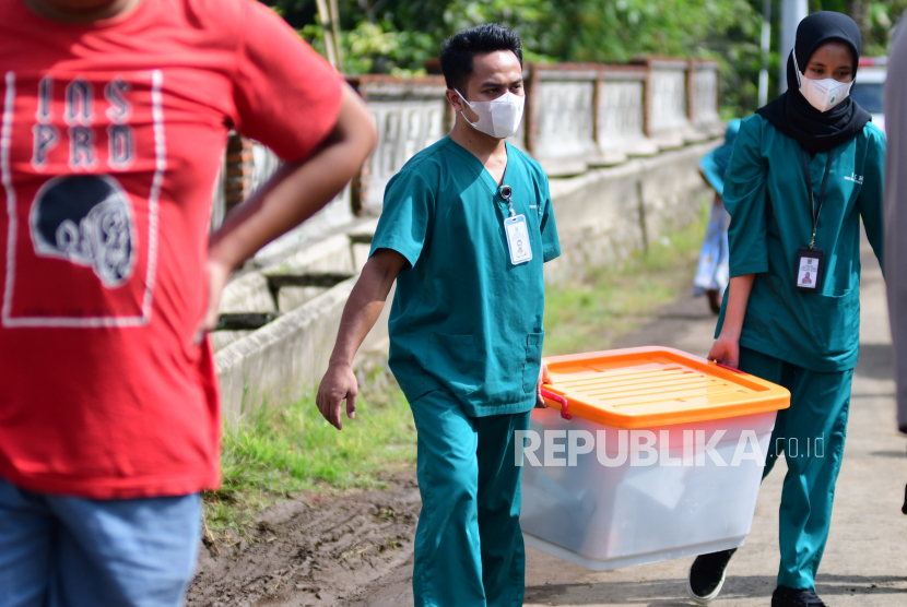 Dua anggota tim dari Perhimpunan Dokter Forensik Indonesia (PDFI) mengangkat kotak peralatan usai melakukan ekshumasi jenazah dua korban Tragedi Kanjuruhan di Tempat Pemakaman Umum (TPU) Desa Sukolilo, Kecamatan Wajak, Malang, Jawa Timur, Sabtu (5/11/2022). Ekshumasi tersebut dilakukan pada dua jenazah korban tragedi kanjuruhan yakni Natasya Debi Ramadani dan Naila Debi Anggraini. ANTARA FOTO/Purnomo/abs/YU