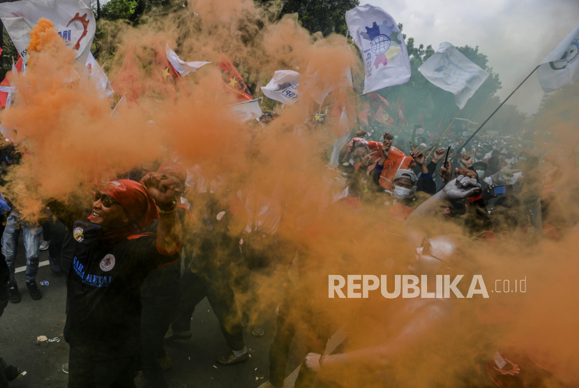 Sejumlah massa buruh menyalakan suar saat melaksanakan aksi unjuk rasa di depan Balai Kota Jakarta, Senin (29/11). Aksi tersebut bertujuan untuk menolak Upah Minimum Provinsi (UMP) DKI Jakarta yang hanya naik Rp 37.749 atau sekitar 0,8 persen dibandingkan tahun lalu. Republika/Putra M. Akbar