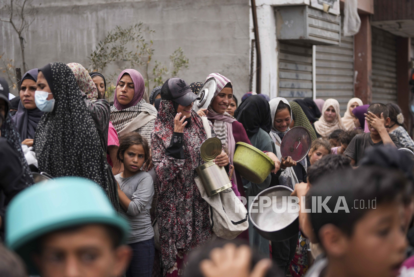 Warga Palestina antre untuk pembagian makanan di Deir al Balah, Gaza, Jumat, (10/5/2024).