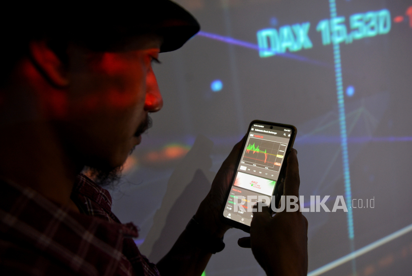 Pengunjung mengamati data saham melalui aplikasi IDX Mobile di dekat layar yang menampilkan indeks harga saham gabungan (IHSG) di kantor PT Bursa Efek Indonesia (BEI) di Jakarta, Kamis (24/8/2023). 
