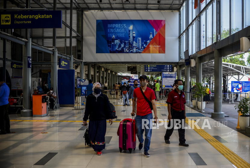 Sejumlah penumpang kereta berjalan membawa koper di Stasiun Pasar Senen, Jakarta, Kamis (8/7). PT Kereta Api Indonesia (Persero) atau KAI memastikan akan mendukung kebijakan pemerintah selama Pemberlakuan Pembatasan Kegiatan Masyarakat (PPKM) Level 4. Salah satunya mengenai pembatasan kapasitas penumpang. 