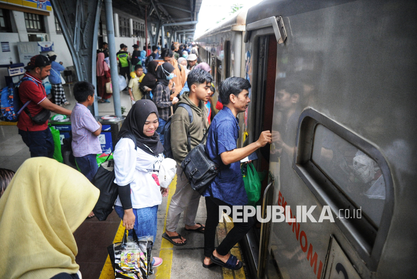 Sejumlah penumpang bersiap memasuki kereta api jarak jauh di Stasiun Pasar Senen, Jakarta Pusat, Ahad (26/1/2025).