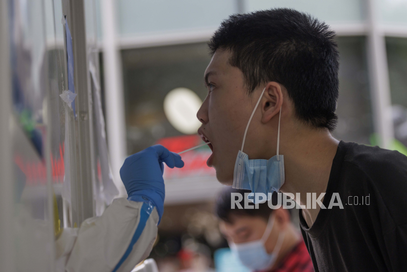 Seorang pria melakukan tes PCR Coronavirus di jalan, di Shanghai, Cina, 12 Juli 2022. Kota Shanghai melaporkan lima kasus COVID-19 yang ditularkan secara lokal dan 54 infeksi tanpa gejala lokal, menurut laporan Komisi Kesehatan Shanghai. Karena penyebaran virus, lebih banyak komunitas yang dikunci lagi. Oleh karena itu kota akan memulai tiga hari wajib tes PCR massal di lebih dari setengah distrik hari ini.