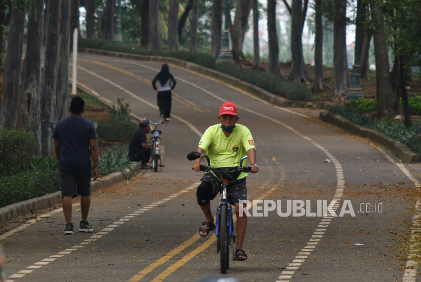 Warga berolahraga menggunakan sepeda di Banjir Kanal Timur (BKT). Pemprov DKI mulai mendata untuk membebaskan lahan dalam pembangunan jalan sejajar BKT.