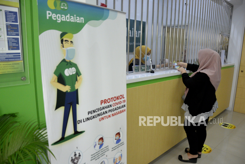 Karyawan PT Pegadaian (Persero) melayani nasabah di kantor Paegadaian Makassar, Sulawesi Selatan, Kamis (15/10). Direktur Utama PT Pegadaian (Persero) Kuswiyoto menyampaikan kinerja Pegadaian hingga pada 2020 relatif positif, kecuali laba yang turun akibat kebijakan bisnis dan operasional selama pandemi. 
