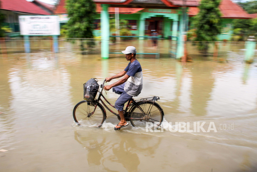 Warga melintas dengan sepeda d itengah banjir meredam wilayah Aceh Singkil (ilustrasi)