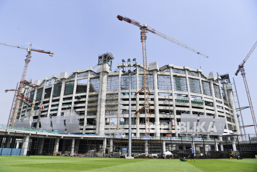 Pekerja memotong rumput lapangan latih di area proyek pembangunan Jakarta International Stadium, Tanjung  Priok, Jakarta, Senin (7/6/2021). Proyek pembangunan stadion berkapasitas  82.000 penonton itu hingga Kamis (3/6) telah mencapai 58,2 persen dan saat ini telah memasuki proses pengangkatan rangka atap bangunan. 