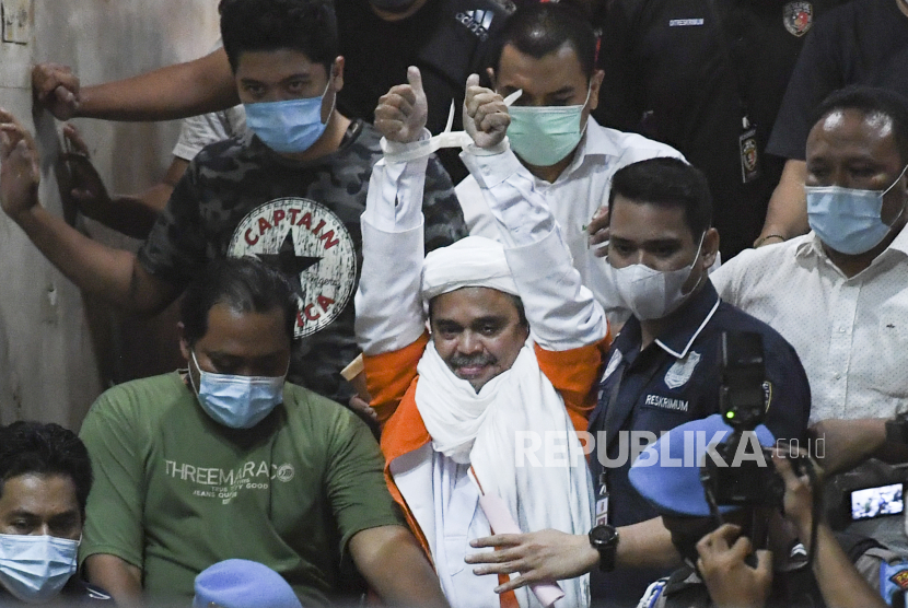 Imam Besar Front Pembela Islam (FPI) Habib Rizieq Shihab atau HRS (tengah) berjalan menuju mobil tahanan usai diperiksa di Mapolda Metro Jaya, Jakarta, Minggu (13/12/2020) dini hari. Rizieq Shihab ditahan penyidik Ditreskrimum Polda Metro Jaya untuk kepentingan penyidikan perkara kasus dugaan pelanggaran protokol kesehatan COVID-19 terkait kerumunan di Petamburan, Tanah Abang, Jakarta pada 14 November lalu. ANTARA FOTO/Hafidz Mubarak A/pras.