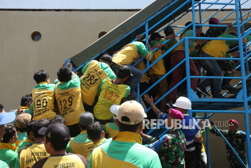Sejumlah buruh angkut atau portir berebut menaiki tangga memasuki Kapal Motor (KM) Dorolonda yang bersandar di Dermaga Jamrud Utara, Pelabuhan Tanjung Perak, Surabaya, Jawa Timur, Rabu (3/4/2024). 
