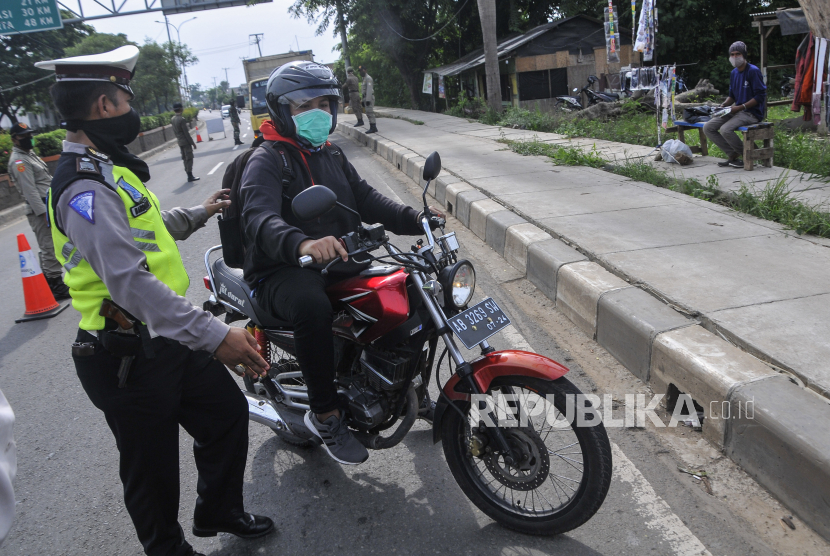 Polisi memberhentikan pengendara motor yang akan mudik.
