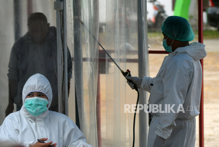 Petugas melakukan sterilisasi kepada warga yang masuk ke wilayah Kota Palu pada jalur Trans Sulawesi di Kelurahan Tawaeli, Palu Utara, Sulawesi Tengah, Selasa (14/4/2020). Pemerintah Provinsi Sulawesi Tengah memperpanjang masa tanggap darurat COVID-19 di daerah tersebut hingga 29 Mei 2020 menyusul masih meningkatnya penyebaran virus tersebut