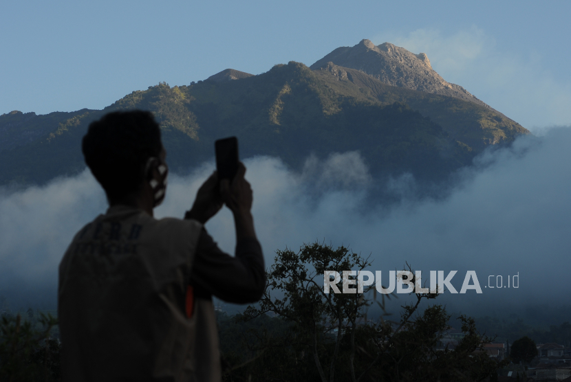 Seorang relawan mengabadikan video suasana Gunung Merapi yang terlihat dari kawasan Selo, Boyolali, Jawa Tengah, Rabu (8/7/2020). Bedasarkan data pengamatan Balai Penyelidikan dan Pengembangan Teknologi Kebencanaan Geologi (BPPTKG), pascaerupsi Gunung Merapi pada 21 Juni 2020 terjadi peningkatan deformasi atau perubahan tubuh Gunung Merapi sebesar 0,5 sentimeter per hari. ANTARA FOTO/Aloysius Jarot Nugroho/foc.