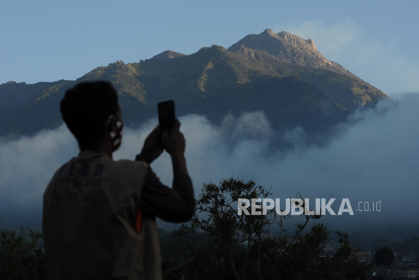 Seorang relawan mengabadikan video suasana Gunung Merapi yang terlihat dari kawasan Selo, Boyolali, Jawa Tengah, Rabu (8/7/2020). Bedasarkan data pengamatan Balai Penyelidikan dan Pengembangan Teknologi Kebencanaan Geologi (BPPTKG), pascaerupsi Gunung Merapi pada 21 Juni 2020 terjadi peningkatan deformasi atau perubahan tubuh Gunung Merapi sebesar 0,5 sentimeter per hari.