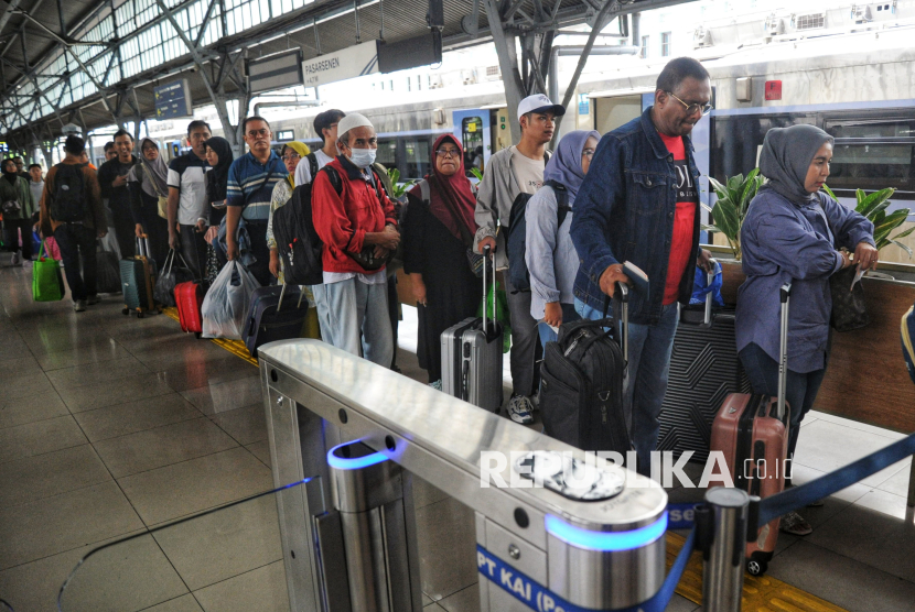 Sejumlah penumpang kereta api jarak jauh antre saat pemeriksaan tiket di Stasiun Pasar Senen, Jakarta Pusat, Ahad (26/1/2025).