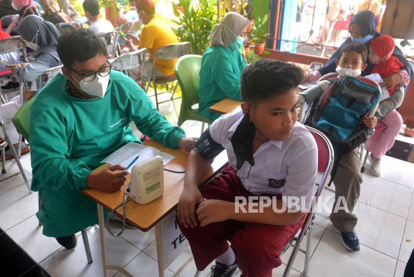 Pemeriksaan kesehatan siswa SD sebelum vaksinasi Covid-19 susulan di SD Muhammadiyah Sagan, Yogyakarta, Selasa (25/1/2022). Beberapa siswa SD terpaksa mengikuti vaksinasi Covid-19 susulan karena berhalangan saat vaksinasi di sekolah asal. Dinas Kesehatan (Dinkes) Kota Yogyakarta mengaku telah menyelesaikan vaksinasi anak usia 6-11 tahun sesuai rekomendasi Kemenkes. Bahkan waktu yang ditargetkan selesai pada Rabu (19/1/2022) lebih cepat dengan capaian 101 persen.