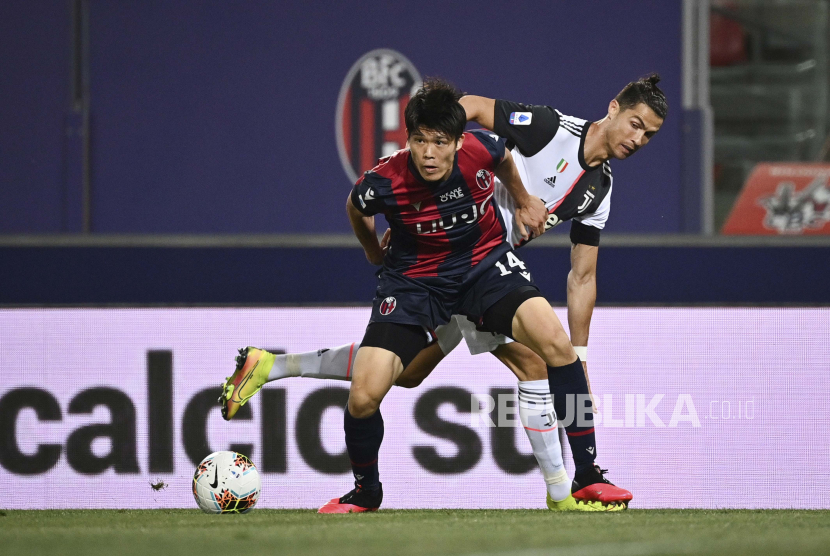 Mantan pemain Juventus Cristiano Ronaldo berusaha berebut bola dari kaki pemain belakang Bologna Takehiro Tomiyasu (kiri).