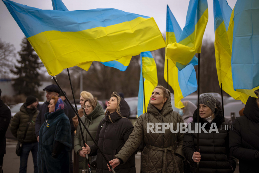  Wanita memegang bendera Ukraina saat mereka berkumpul untuk merayakan Hari Persatuan di Odessa, Ukraina, Rabu, 16 Februari 2022. Grup Bank Dunia mengatakan pada Sabtu (19/2), menyiapkan pencairan 350 juta dolar AS ke Ukraina sebagai bagian dari rencana pendanaan jangka pendek dan panjang. 