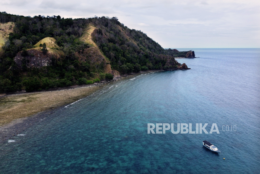 Perahu wisata berlabuh di pesisir obyek wisata alam Bukit Larata di Desa Kinunang, Likupang Timur, Minahasa Utara, Sulawesi Utara.