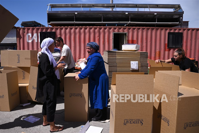 Orang-orang bekerja mengemas bantuan yang ditujukan untuk korban gempa Turki di luar Sultan Butcher di Campbellfield, tempat Necmi Kul dan istrinya Necmiye telah menyiapkan kontainer pengiriman di belakang toko mereka untuk mengumpulkan bantuan bagi korban gempa di Turki, di Melbourne, Australia, Rabu (8/2/2023). 