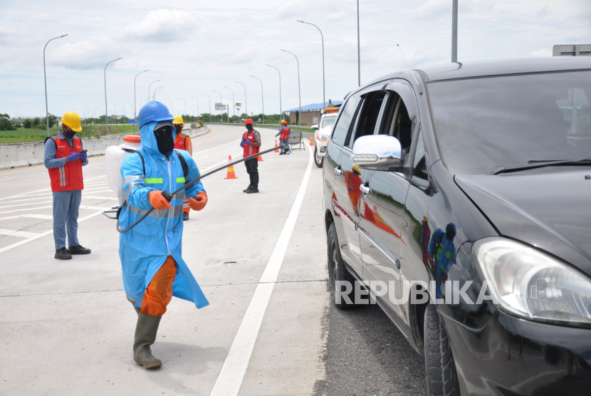 Petugas medis PT Hutama Karya menyemprotkan cairan disinfektan milik mobil  pengguna jalan tol yang diduga terpapar virus COVID-19 saat melakukan simulasi kesiapan penanganan COVID-19 pengguna jalan tol Trans Sumatera Medan-Binjai , Sumatera Utara, Kamis (30/4/2020). PT Hutama Karya selaku operator jalan tol Medan-Binjai turut aktif melakukan antisipasi pencegahan penyebaran COVID-19 lewat simulasi penanganan pengguna jalan tol yang diduga gejala COVID-19