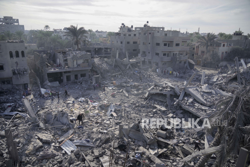 Warga Palestina menyaksikan kehancuran akibat bombardir Israel di Jalur Gaza, Palestina, di Deir al Balah, Rabu (22/11/2023).