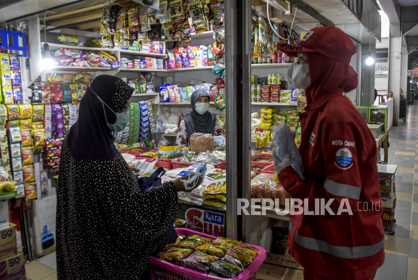 Petugas dari Palang Merah Indonesia (PMI) Kota Cimahi membagikan masker ke pedagang di Pasar Atas Cimahi, Kota Cimahi, Ahad (20/2/2022). BNPB bersama Pemerintah Kota Cimahi dan instansi terkait membagikan sedikitnya 100 ribu masker di 10 titik di Kota Cimahi dalam rangka program berbagi 15 juta masker di seluruh Indonesia. Program berbagi masker tersebut merupakan upaya agar masyarakat lebih patuh terhadap protokol kesehatan guna meminimalisir penyebaran Covid-19. Foto: Republika/Abdan Syakura