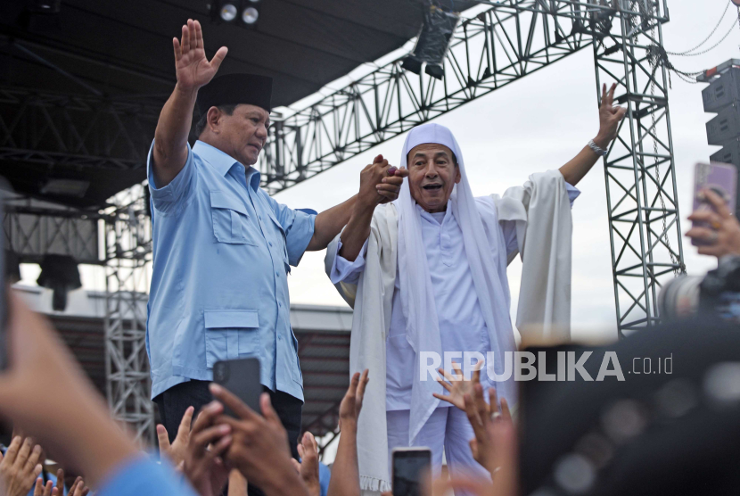 Calon presiden nomor urut 2 Prabowo Subianto (kiri) menggandeng tangan tokoh agama Habib Lutfi bin Yahya (kanan) saat menghadiri kampanye di Stadion Maulana Yusuf, Serang, Banten, Sabtu (27/1/2024). Di sela-sela kampanye Prabowo menerima dukungan dari sejumlah relawan santri dan ulama Banten. 