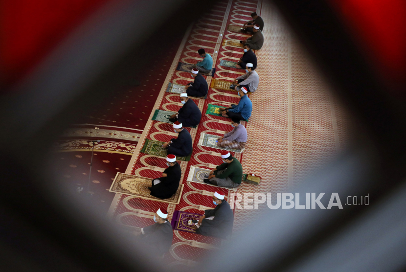 Umat Muslim mengenakan masker dan menerapkan jarak sosial berdoa di dalam Masjid Nasional, Kuala Lumpur, Malaysia, Jumat (15/5). Malaysia melonggarkan aturan larangan sholat jamaahl di masjid-masjid saat pandemi virus corona