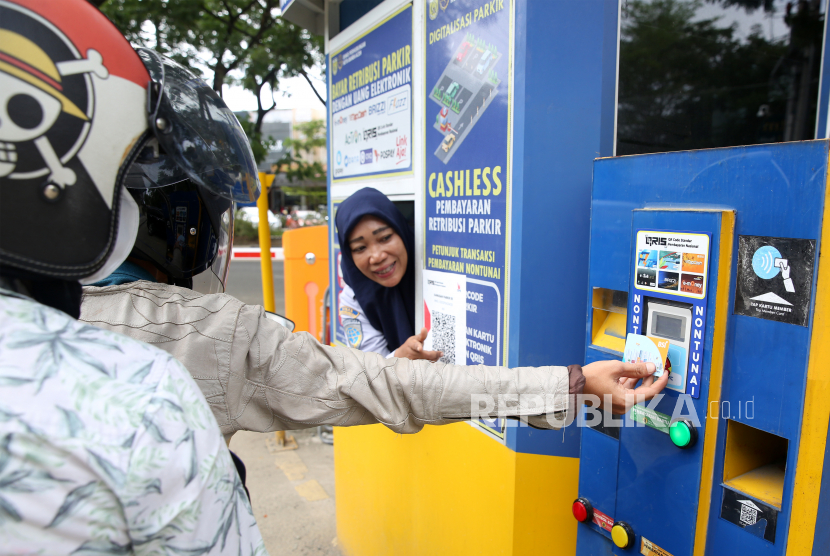 Petugas mengarahkan warga menggunakan parkir elektronik (e-parking) melalui transaksi non tunai di Banda Aceh, Aceh, Rabu  (28/12/2022). Pemerintah setempat telah menerapkan program digitalisasi parkir elektronik dengan metode pembayaran non tunai dengan menggunakan e-money, kartu debit, dan QRIS sebagai upaya mewujudkan transparansi serta mengatasi pungutan parkir liar dan meningkatkan pendapatan daerah dari sektor perparkiran. 