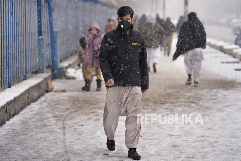 Seorang pria Afghanistan memakai masker untuk membantu mengekang penyebaran COVID-19, saat dia berjalan di salju, di Kabul, Afghanistan, Minggu, 6 Februari 2022. Kedatangan wartawan asing, turis, dan peneliti membuka lapangan kerja di Afghanistan. Ilustrasi.