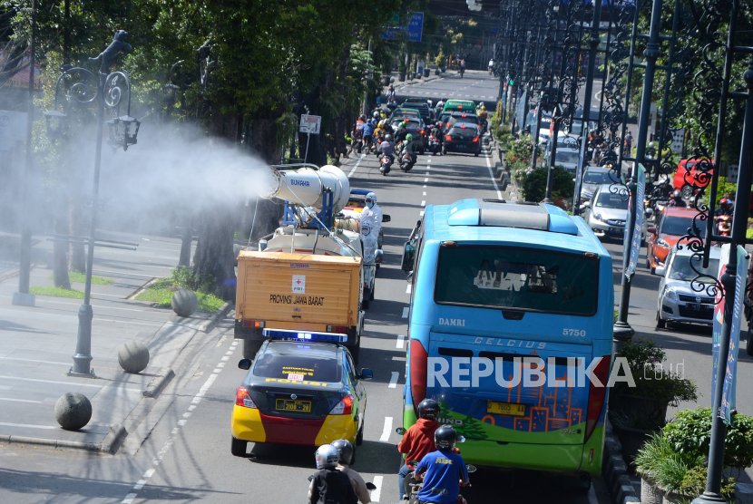 Petugas Palang Merah Indonesia (PMI) Provinsi Jawa Barat menyemprotkan desinfektan dengan menggunakan armada gunner, di Jalan Ir H Djuanda, Kota Bandung, Kamsi (11/2). Di masa PSBB Proporsional di Jawa Barat, petugas terus melakukan upaya penanganan pencegahan Covid-19 salah satunya dengan penyemprotan disinfektan secara masif di tempat umum khususnya di lokasi tempat biasa berkumpulnya banyak orang.