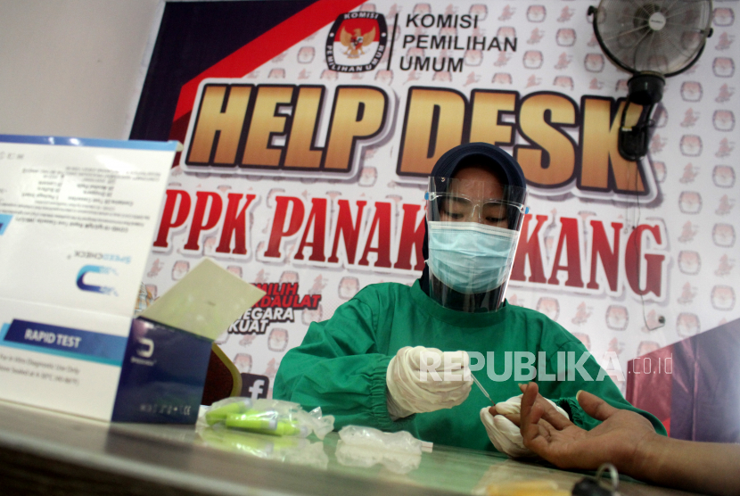 Tenaga medis melakukan tes cepat (rapid test) terhadap petugas Panitia Pemilihan Kecamatan (PPK) dan Panitia Pemungutan Suara (PPS) di Kantor Kecamatan Panakukang, Makassar, Sulawesi Selatan, Selasa (17/11/2020). KPU Kota Makassar menggelar tes cepat bagi petugas PPK dan PPS se-Makassar untuk mengantisipasi penularan COVID-19 jelang pilkada serentak pada 9 Desember 2020. 