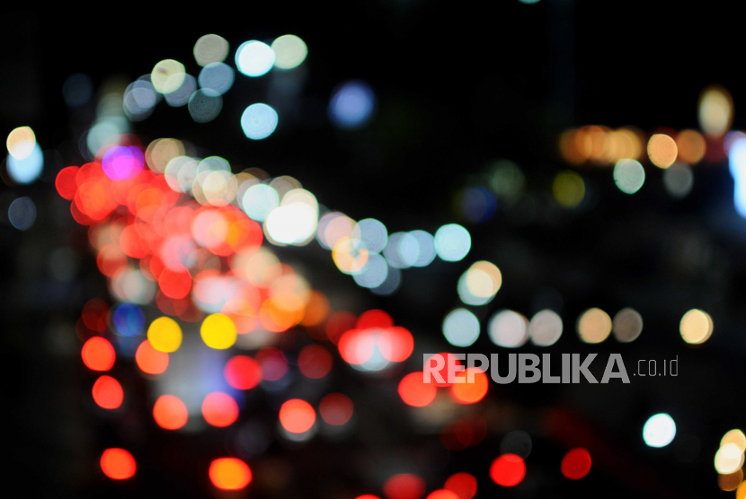 Pendar cahaya dari lampu kendaraan yang terjebak kemacetan di Jalan Raya Margonda, Depok, Jawa Barat.