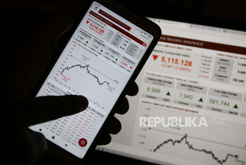 Karyawan mengamati pergerakan Indeks Harga Saham Gabungan (IHSG) melalui layar telepon selular di Jakarta, Senin (2/11/2020). 