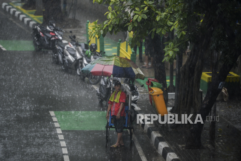 Pedagang berteduh saat hujan deras (ilustrasi). Hujan termasuk salah satu perkara gaib yang dirahasiakan Allah SWT 