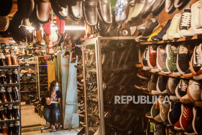 Seorang penjual sepatu yang memakai masker pelindung menunggu pelanggan di sebuah pasar di Medan, Indonesia, 15 September 2021. Menurut pernyataan Presiden Joko Widodo, pertumbuhan ekonomi Indonesia tahun 2022 ditargetkan pada kisaran 5 hingga 5,5 persen di tengah COVID-19 pandemi.