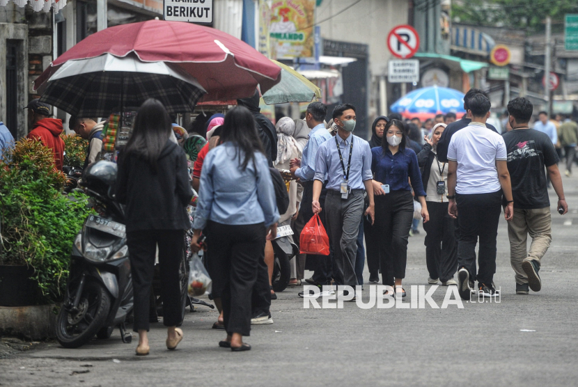 Pekerja kantoran berjalan usai makan siang di salah satu warung di Kawasan Perkantoran Setiabudi, Jakarta, Senin (7/4/2025). Badan Pusat Statistik mencatat ekonomi kuartal I 2025 tumbuh 4,8 persen.