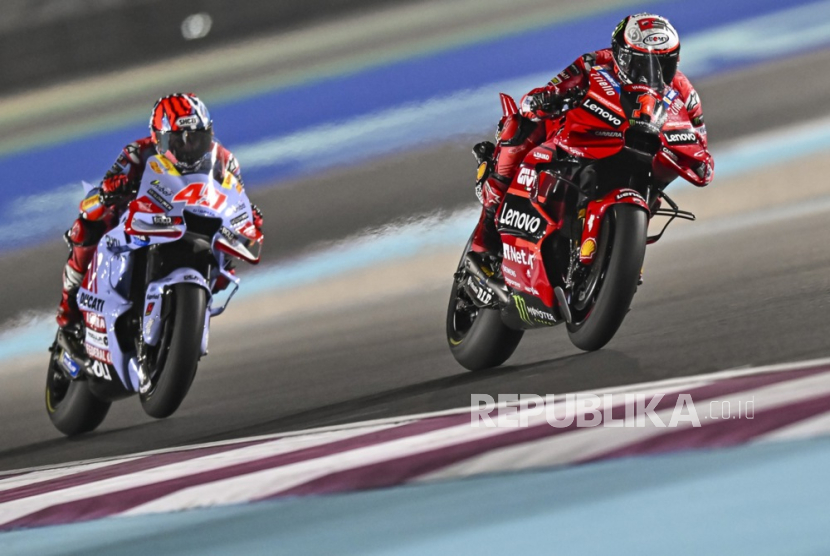 Pembalap Italia Francesco Bagnaia (kanan) dari Ducati Lenovo Team dan pebalap Italia Fabio Di Giannantonio (kiri) dari Gresini Racing beraksi saat balapan MotoGP Grand Prix Sepeda Motor Qatar di Sirkuit Internasional Losail di Doha, Qatar, Senin (20/11/2023)dini hari WIB.