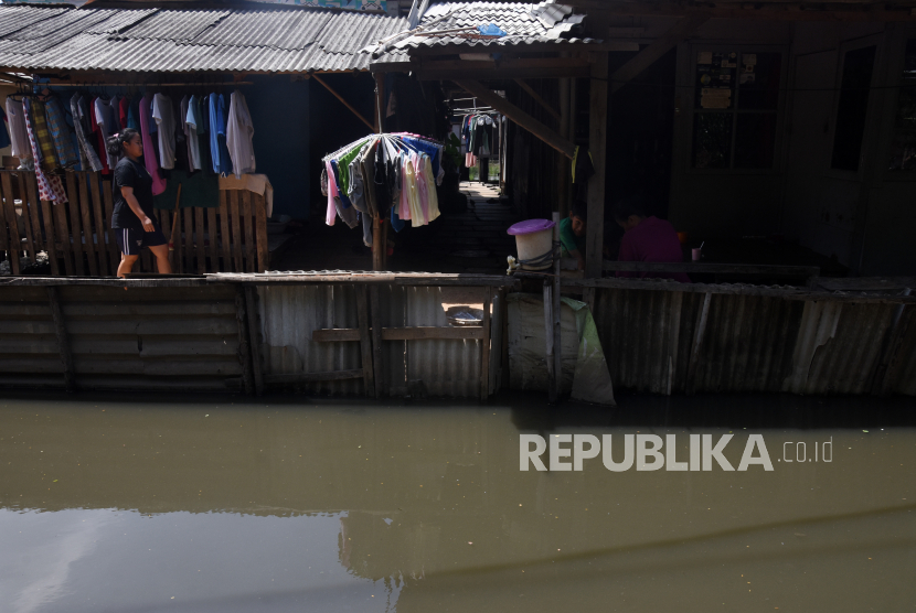 Warga beraktivitas di depan rumahnya di Jalan Kamal Muara, Jakarta Utara, Senin (24/1/2022). Menurut warga setempat, permukiman tersebut rentan banjir akibat luapan Kali Semonggol dan rob dari muara di Kamal Muara. 