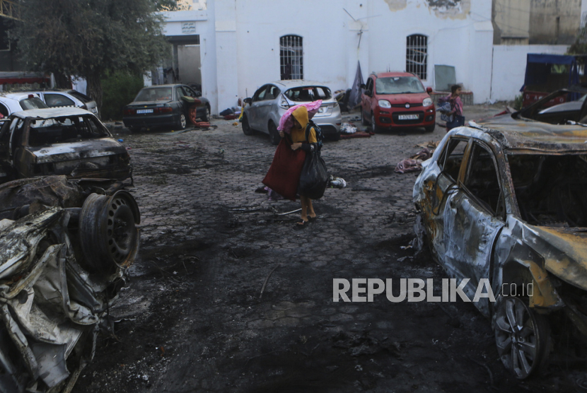 Warga Palestina membawa barang-barang mereka meninggalkan rumah sakit al-Ahli, yang mereka jadikan sebagai tempat berlindung, di Kota Gaza, Rabu, (18/10/2023). 