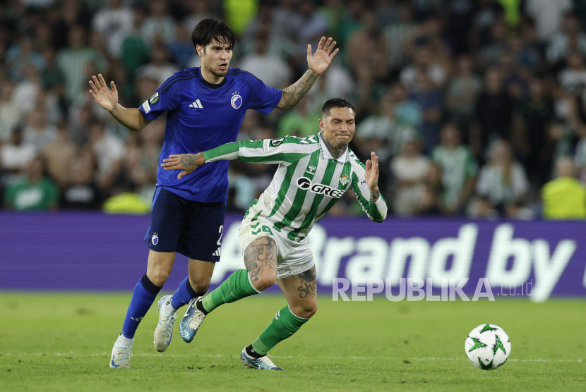 Pemain FC Copenhaguen Kevin Diks (kiri) berebut bola dengan pemain Real Betis Chimy Avila pada pertandingan sepak bola UEFA Europa Conference League di Sevile, Spanyol, Jumat (25/10/2024) WIB.