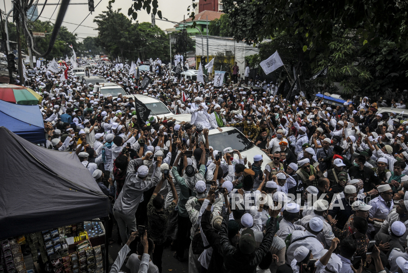 Imam Besar Front Pembela Islam (FPI) Habib Rizieq Shihab menyapa massa saat tiba di kawasan Petamburan, Jakarta, Selasa (10/11). Kerumunan massa di markas FPI itu membuat Camat Tanah Abang menerima panggilan klarifikasi dari kepolisian.