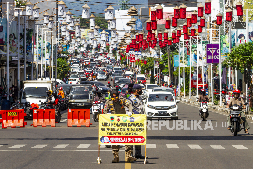 Petugas gabungan memasang plang pemberitahuan pemeriksaan penerapan Pembatasan Sosial Berskala Besar (PSBB) di Jalan Laks. Laut RE Martadinata, Purwakarta, Jawa Barat, Senin (11/5/2020)