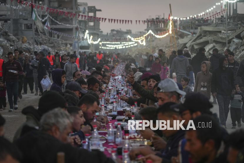 Warga Palestina berbuka puasa bersama diantara reruntuhan rumah dan bangunan di Rafah, Jalur Gaza selatan, Sabtu (1/3/2025). Pasca gencatan senjata, warga Palestina menjalani bulan suci Ramadhan dengan lebih baik jika dibandingkan tahun sebelumnya. Meski hidup ditengah kondisi kota yang hancur, namun pada Ramadhan tahun ini warga Palestina di Gaza bisa melakukan buka puasa dan ibadah Ramadhan bersama dengan tenang. 