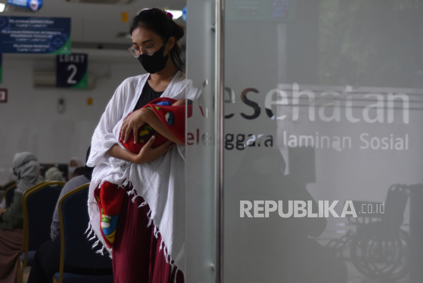 Seorang ibu bersama bayinya antre mengurus layanan asuransi kesehatan di Kantor BPJS Kesehatan Cabang Jakarta Timur, Rawamangun, Jakarta, Kamis (24/11/2022). Kepesertaan JKN melonjak pesat dari 133,4 juta jiwa pada tahun 2014 menjadi 248,7 juta jiwa pada 2022. 