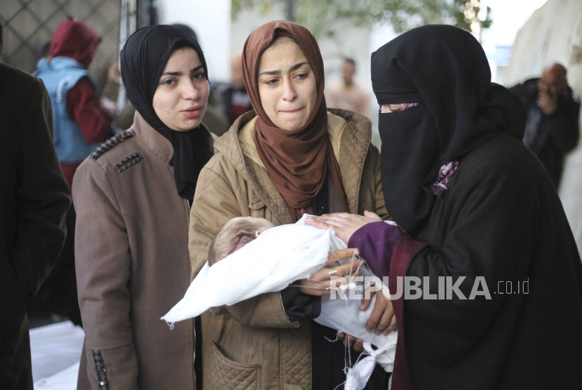 Warga Palestina berduka atas kematian seorang anak dalam pemboman Israel di Jalur Gaza di kamar mayat rumah sakit di Rafah, Senin, (12/2/2024).