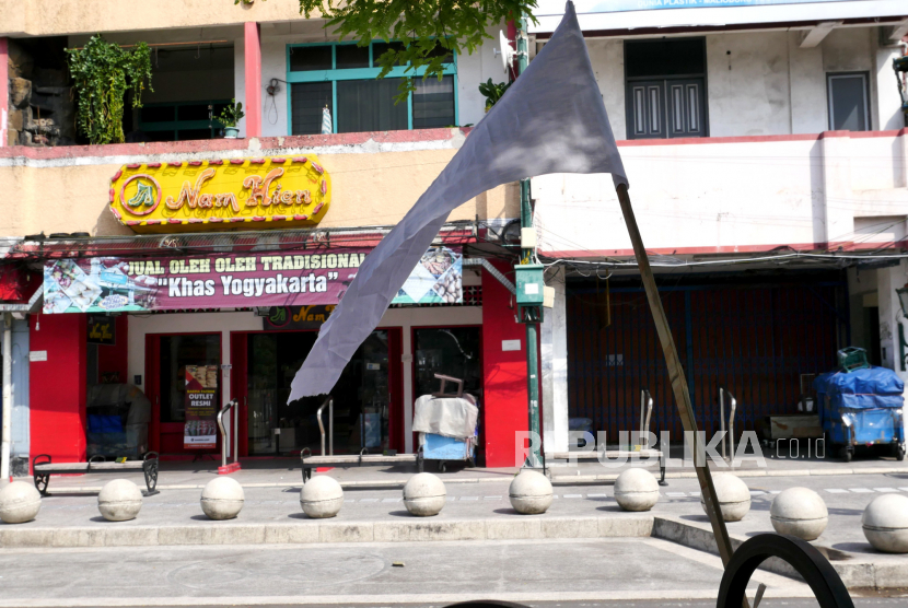 Bendera putih tanda berkabung dipasang di tepi Jalan Malioboro, Yogyakarta, Jumat (30/7). Pemasangan bendera putih ini sebagai tanda simbolis kesulitan pedagang di tengah PPKM dan perpanjangannya. PPKM diperkirakan akan menurunkan laju pertumbuhan ekonomi Indonesia di kuartal III.