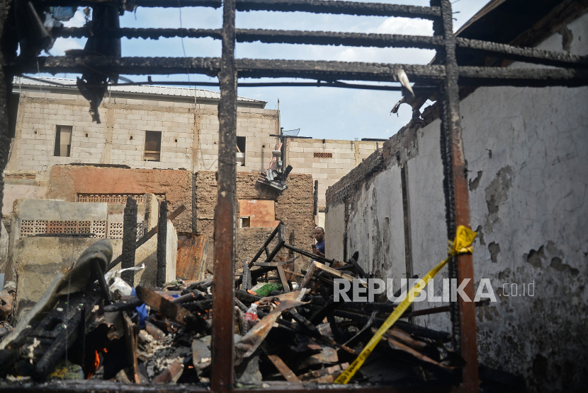 Warga melihat puing-puing rumah yang hangus terbakar di kawasan Kali Pasir, Cikini, Jakarta Pusat, Sabtu (18/12).